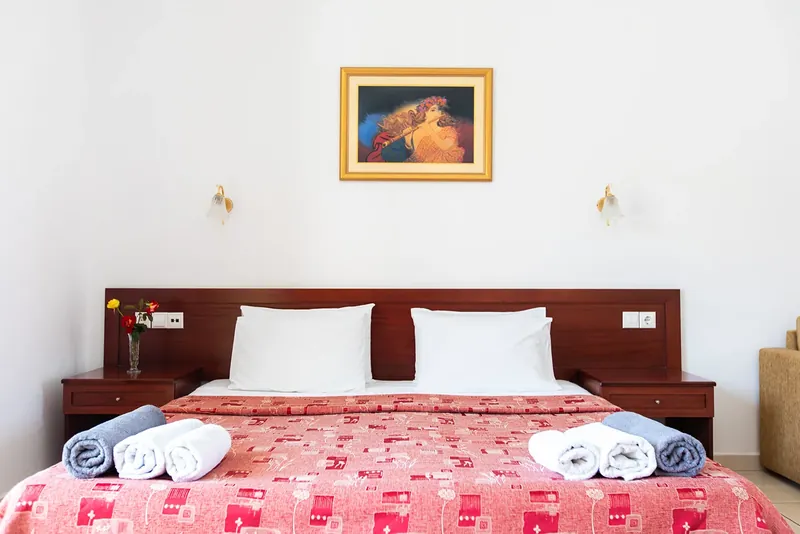 A double bed under a painting