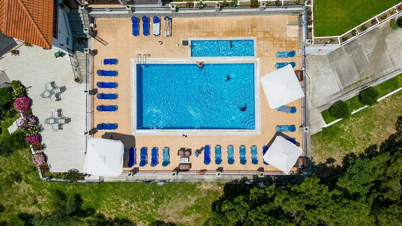 The pool, sunbeds and umbrellas seen from straight above